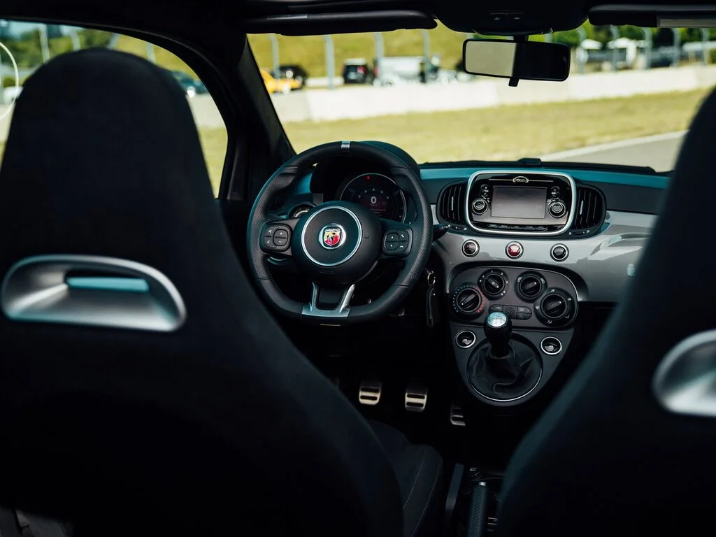 Фото Abarth 595 (2022) — интерьер. Общий план салона: панель, консоль и передние кресла Abarth 595 (2022) — интерьер