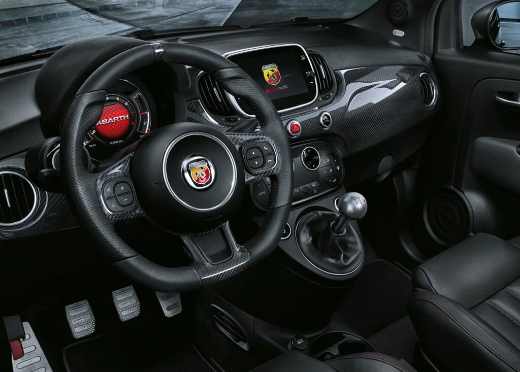 Фото Abarth 695 (2024) — интерьер. Общий план салона: панель, консоль и передние кресла Abarth 695 (2024) — интерьер