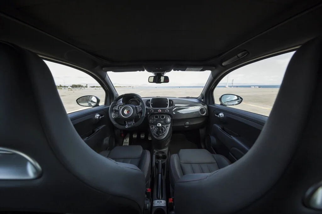 Фото Abarth 695 (2024) — интерьер, фото 4. Общий план салона: панель, консоль и передние кресла Abarth 695 (2024) — интерьер, фото 4