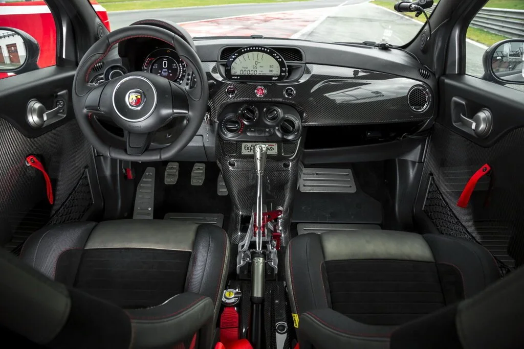 Фото Abarth 695 (2024) — интерьер, фото 5. Салон целиком: как расставлены кресла и что под рукой у водителя Abarth 695 (2024) — интерьер, фото 5