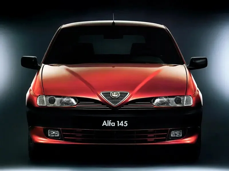 Фото Alfa Romeo 145 (1999) — вид спереди. Анфас: решётка, форма фар и бампер — по ним модель и узнают на дороге Alfa Romeo 145 (1999) — вид спереди