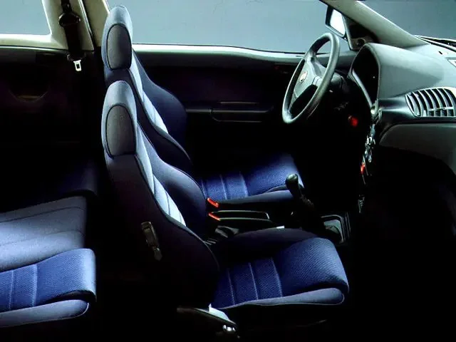 Фото Alfa Romeo 145 (1999) — интерьер. Общий план салона: панель, консоль и передние кресла Alfa Romeo 145 (1999) — интерьер
