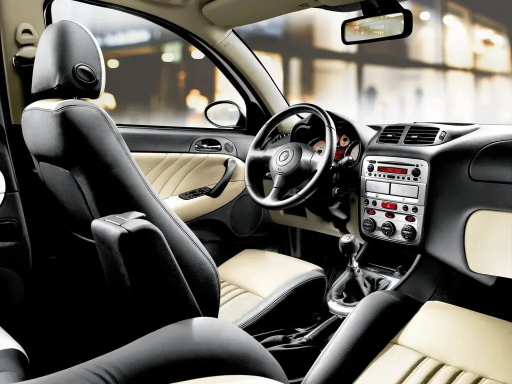 Фото Alfa Romeo 147 (2010) — интерьер. Общий план салона: панель, консоль и передние кресла Alfa Romeo 147 (2010) — интерьер