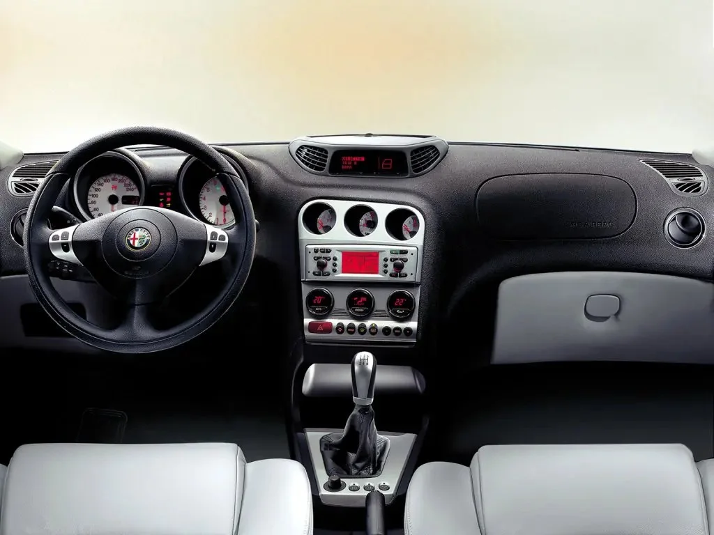 Фото Alfa Romeo 156 (2007) — интерьер. Общий план салона: панель, консоль и передние кресла Alfa Romeo 156 (2007) — интерьер