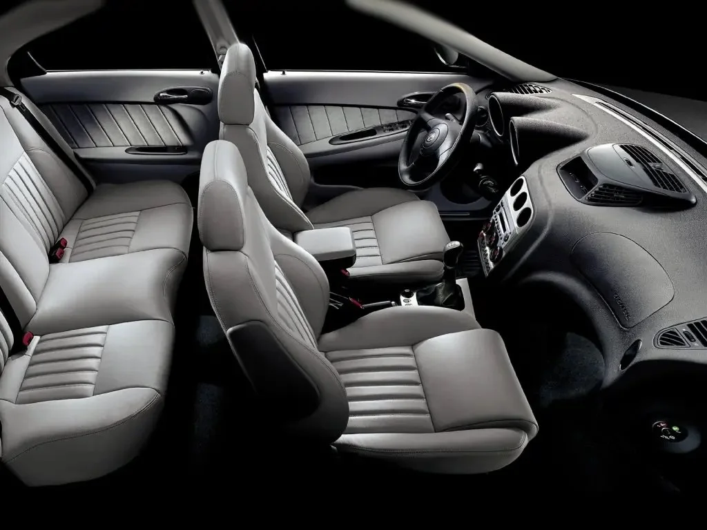 Фото Alfa Romeo 156 (2007) — интерьер, фото 4. Общий план салона: панель, консоль и передние кресла Alfa Romeo 156 (2007) — интерьер, фото 4