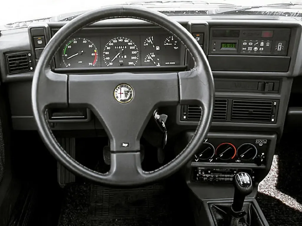 Фото Alfa Romeo 75 (1988) — передняя панель. Архитектура передней панели: экраны, дефлекторы и отделка Alfa Romeo 75 (1988) — передняя панель