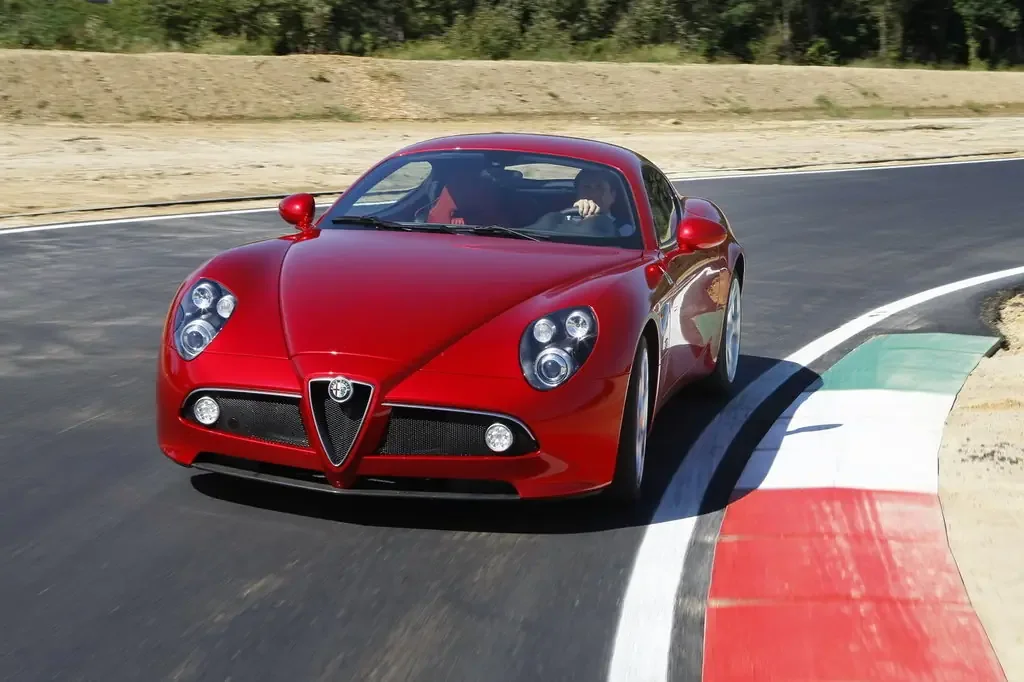 Фото Alfa Romeo 8C (2010) — вид спереди, фото 4. Анфас: решётка, форма фар и бампер — по ним модель и узнают на дороге Alfa Romeo 8C (2010) — вид спереди, фото 4