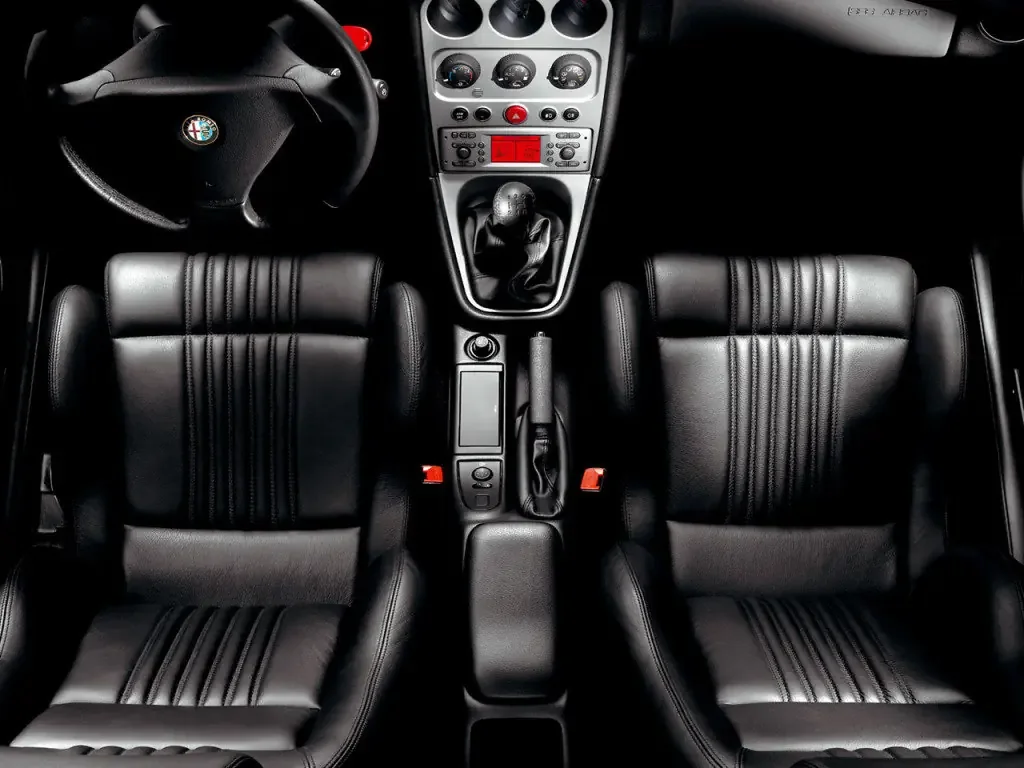 Фото Alfa Romeo GTV (2003) — интерьер. Общий план салона: панель, консоль и передние кресла Alfa Romeo GTV (2003) — интерьер
