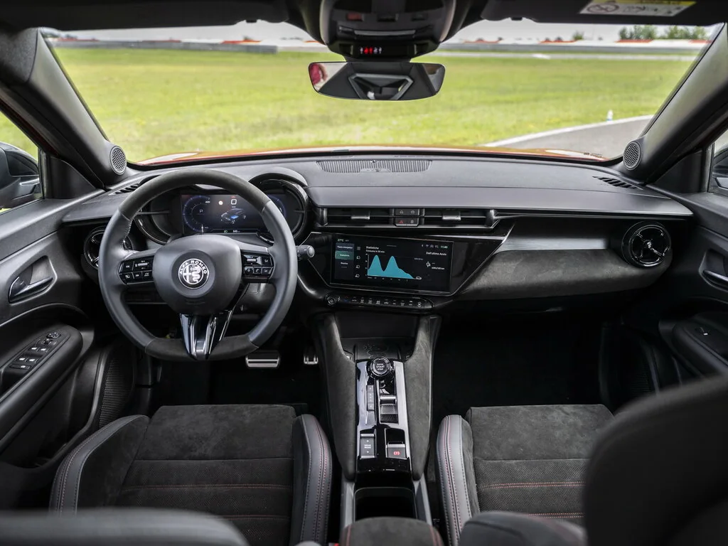 Фото Alfa Romeo Junior (2025) — интерьер. Общий план салона: панель, консоль и передние кресла Alfa Romeo Junior (2025) — интерьер