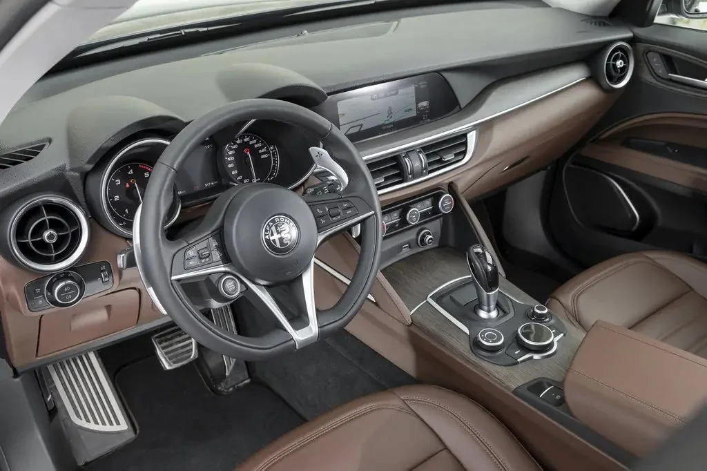 Фото Alfa Romeo Stelvio (2023) — интерьер, фото 7. Общий план салона: панель, консоль и передние кресла Alfa Romeo Stelvio (2023) — интерьер, фото 7