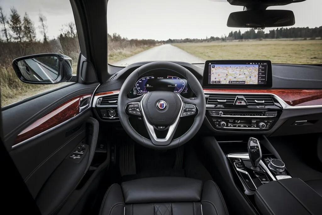 Фото Alpina B5 (2023) — интерьер. Общий план салона: панель, консоль и передние кресла Alpina B5 (2023) — интерьер