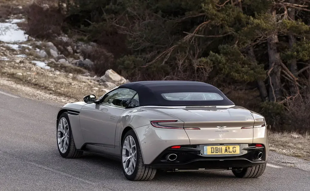 Фото Aston Martin DB11 (2023) — вид сзади, фото 2. Задняя часть крупно: ширина кормы и выпускная система Aston Martin DB11 (2023) — вид сзади, фото 2