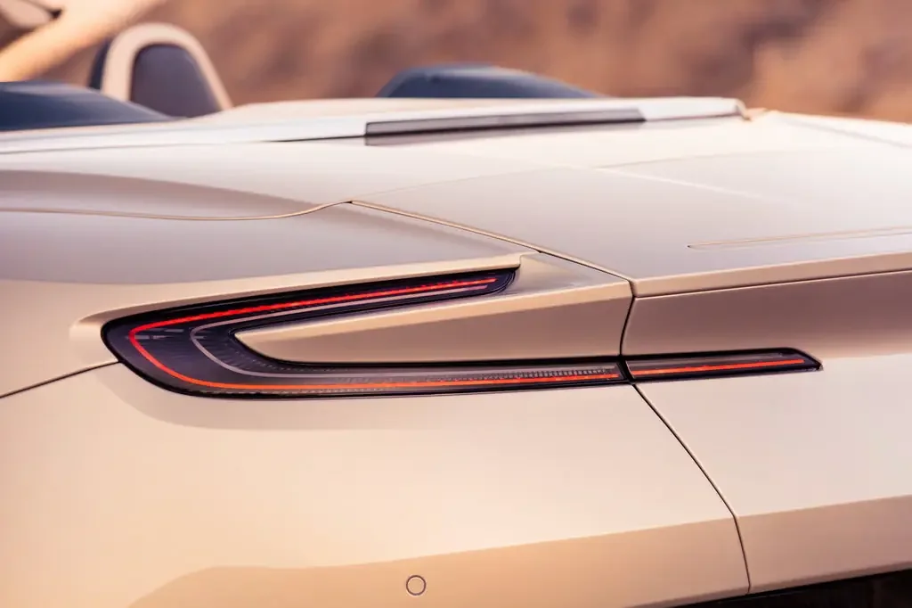 Фото Aston Martin DB11 (2023) — вид сзади, фото 3. Сзади-сбоку: свес кормы и стойка пятой двери Aston Martin DB11 (2023) — вид сзади, фото 3