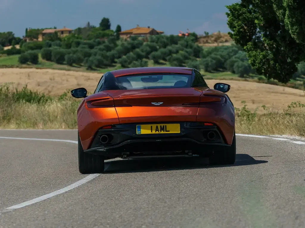 Фото Aston Martin DB11 (2023) — вид сзади, фото 6. Сзади-сбоку: свес кормы и стойка пятой двери Aston Martin DB11 (2023) — вид сзади, фото 6