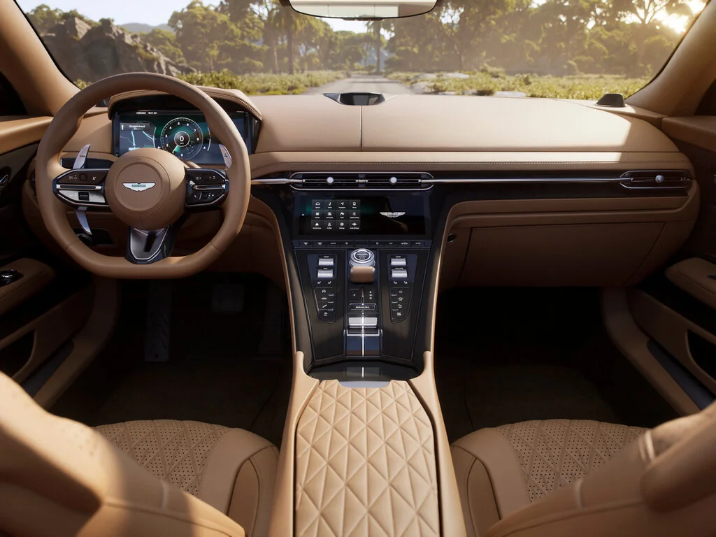 Фото Aston Martin DB12 (2026) — интерьер. Общий план салона: панель, консоль и передние кресла Aston Martin DB12 (2026) — интерьер