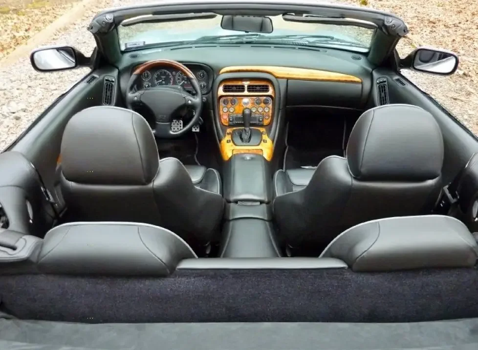 Фото Aston Martin DB7 (2003) — интерьер. Общий план салона: панель, консоль и передние кресла Aston Martin DB7 (2003) — интерьер