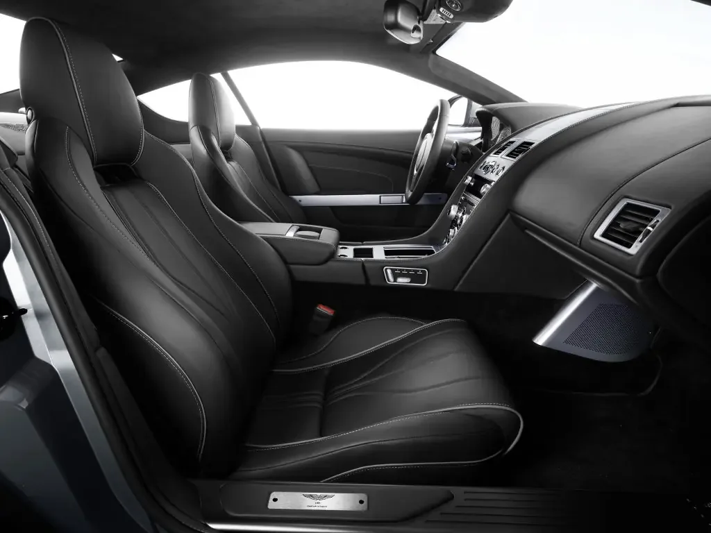 Фото Aston Martin DB9 (2016) — интерьер. Общий план салона: панель, консоль и передние кресла Aston Martin DB9 (2016) — интерьер