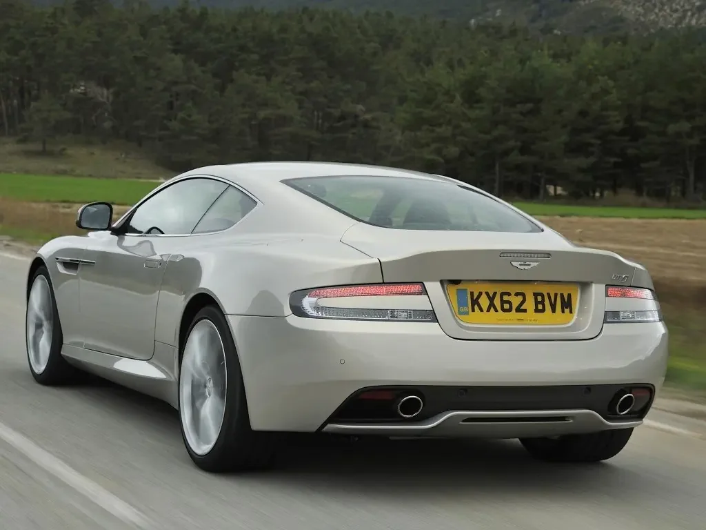 Фото Aston Martin DB9 (2016) — вид сзади, фото 3. Сзади-сбоку: свес кормы и стойка пятой двери Aston Martin DB9 (2016) — вид сзади, фото 3
