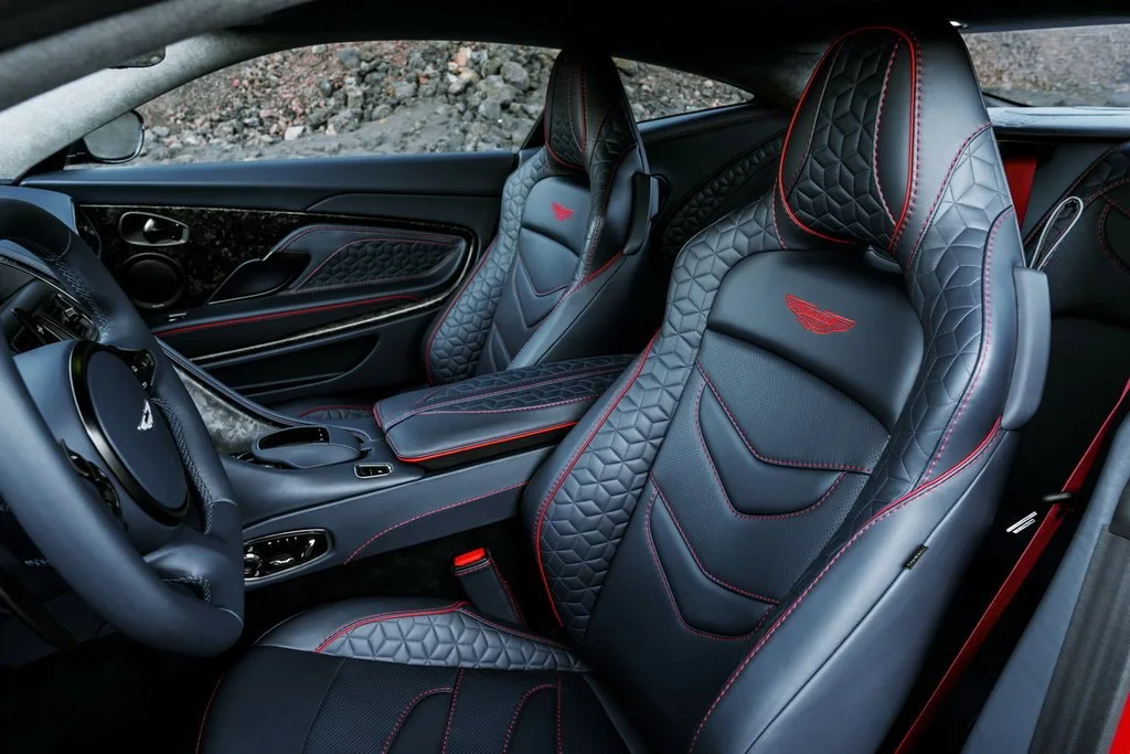 Фото Aston Martin DBS (2022) — интерьер. Общий план салона: панель, консоль и передние кресла Aston Martin DBS (2022) — интерьер