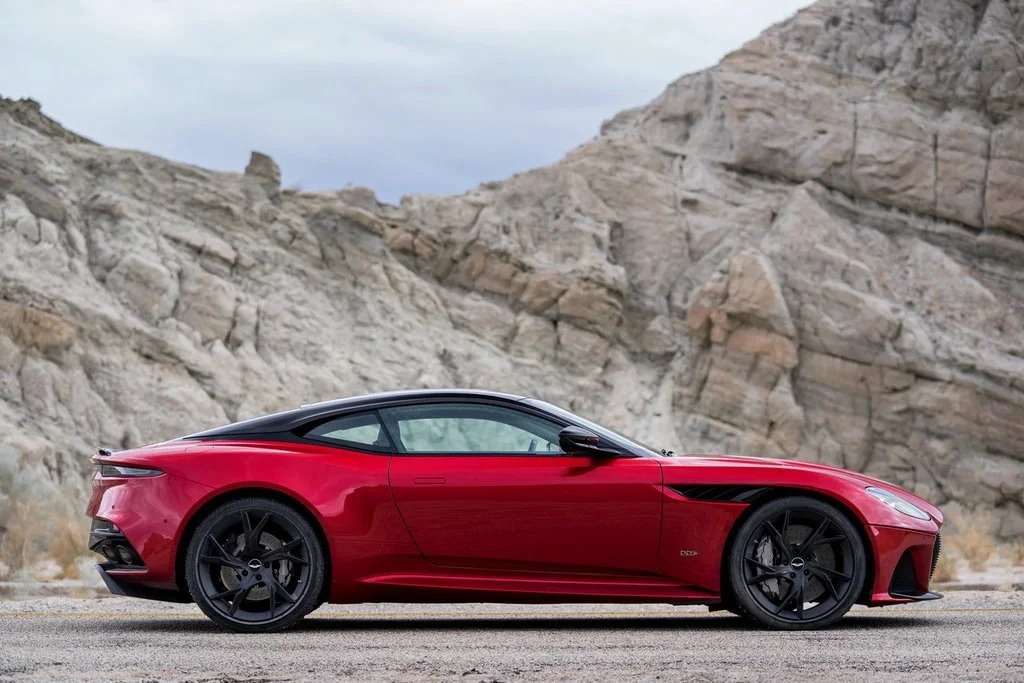Фото Aston Martin DBS (2022) — вид сбоку. Профиль: длина кузова, линия крыши и посадка на колёсах Aston Martin DBS (2022) — вид сбоку
