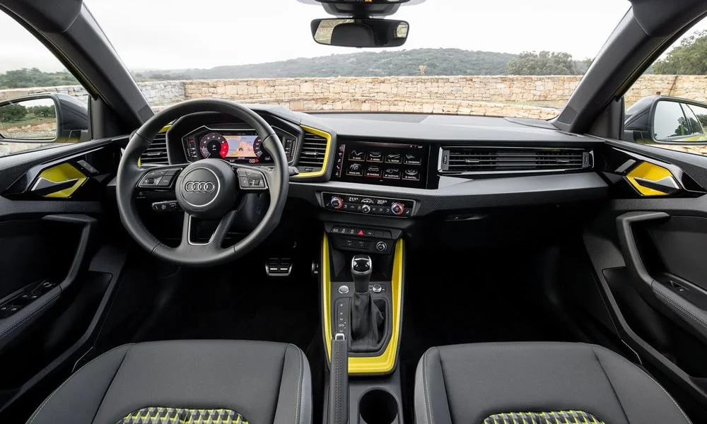 Фото Audi A1 Sportback — передняя панель. Передняя панель в тёмной отделке: расположение экранов и дефлекторов. Минимум физических кнопок — ставка на экранное управление Audi A1 Sportback — передняя панель