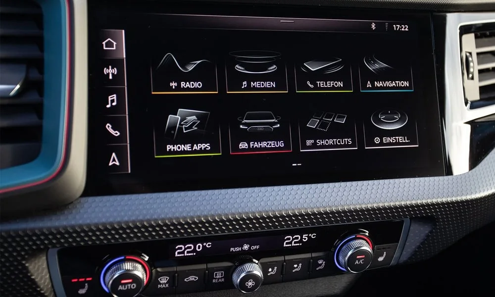 Фото Audi A1 Sportback — экран мультимедиа. Интерфейс медиасистемы крупным планом. Климат и обогревы часто управляются с этого экрана — привыкание занимает пару дней Audi A1 Sportback — экран мультимедиа