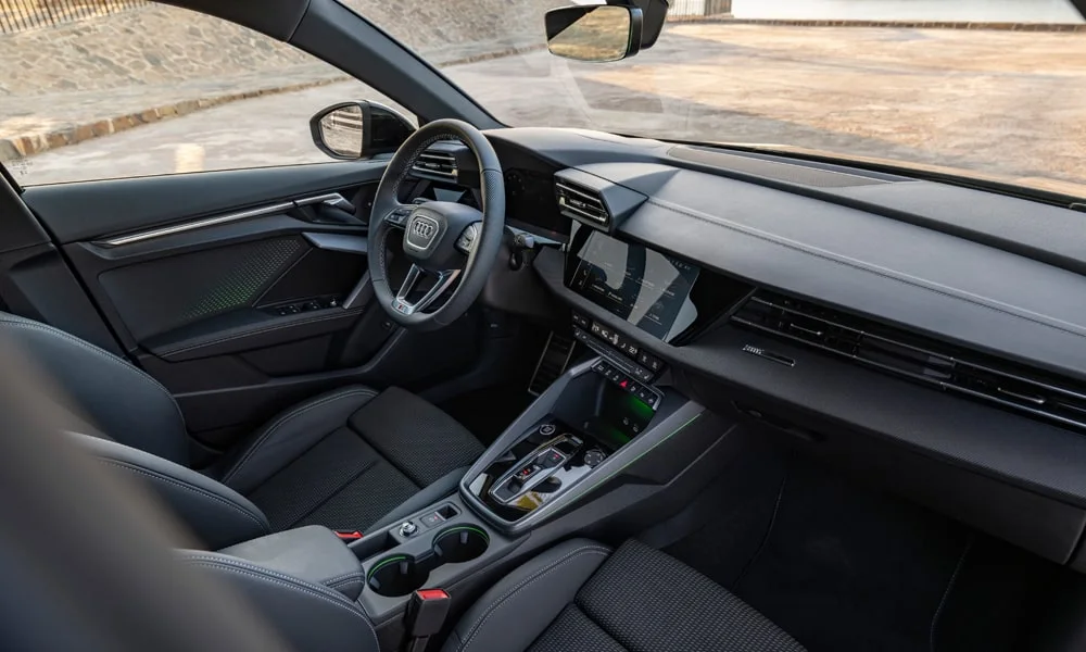 Фото Audi A3 — интерьер, фото 2. Интерьер с тёмной отделкой — видно сочетание материалов панели и кресел. Уровень отделки читается по стыкам панелей и мягким поверхностям в зонах касания Audi A3 — интерьер, фото 2
