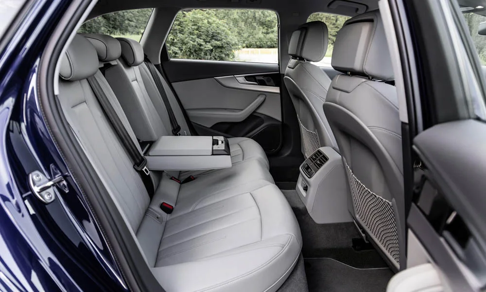 Фото Audi A4 Avant — задние сиденья, фото 2. Посадка второго ряда: подголовники и подлокотник. Плоский пол упрощает посадку втроём Audi A4 Avant — задние сиденья, фото 2