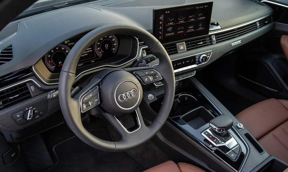 Фото Audi A4 — передняя панель. Архитектура передней панели: ярусы, вставки и консоль в коричневой гамме. Минимум физических кнопок — ставка на экранное управление Audi A4 — передняя панель