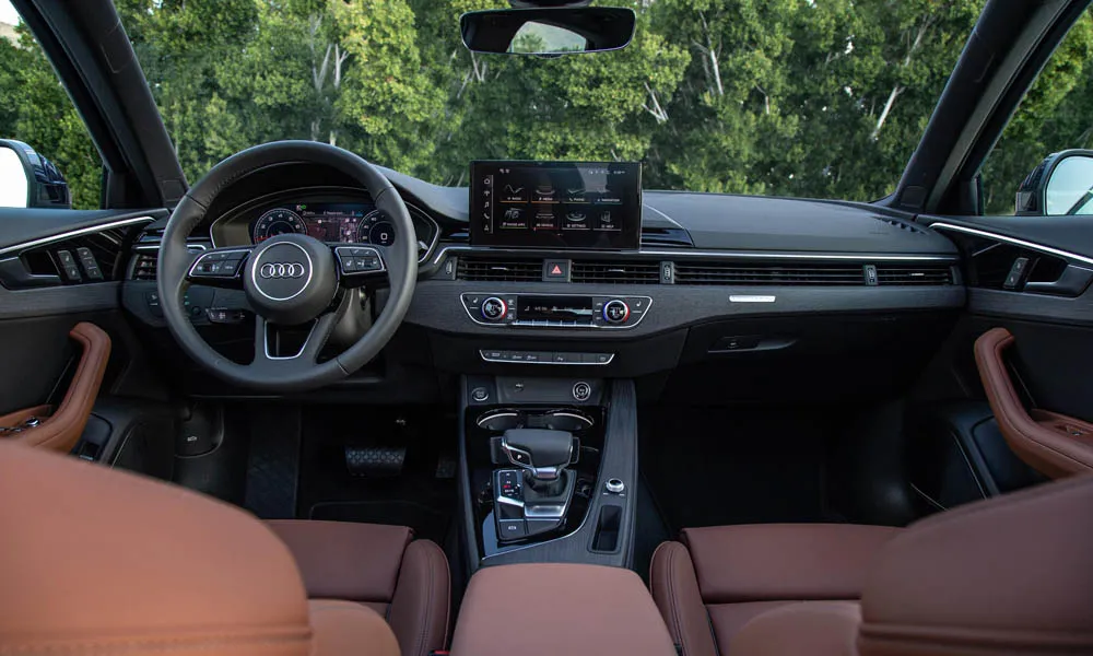 Фото Audi A4 — интерьер. Салон в коричневой отделке: архитектура передней панели, консоль и кресла. Светлая гамма зрительно расширяет салон, тёмная — практичнее в уходе Audi A4 — интерьер