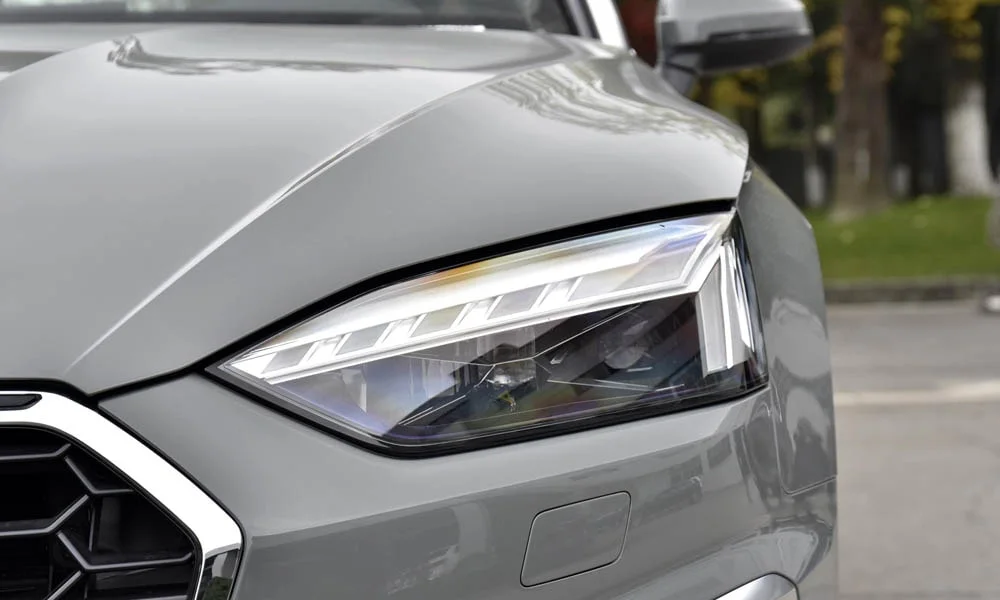 Фото Audi A5 (2024) — вид спереди, фото 4. Анфас: пропорции капота, посадка кузова и графика ходовых огней. Рисунок ходовых огней — подпись модели, по нему её узнают в потоке Audi A5 (2024) — вид спереди, фото 4