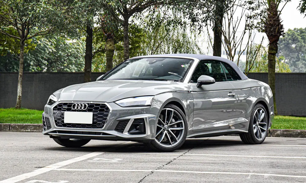 Фото Audi A5 (2024) — вид спереди, фото 5. Передок в сером исполнении — крупная светотехника и выразительный бампер. Рисунок ходовых огней — подпись модели, по нему её узнают в потоке Audi A5 (2024) — вид спереди, фото 5