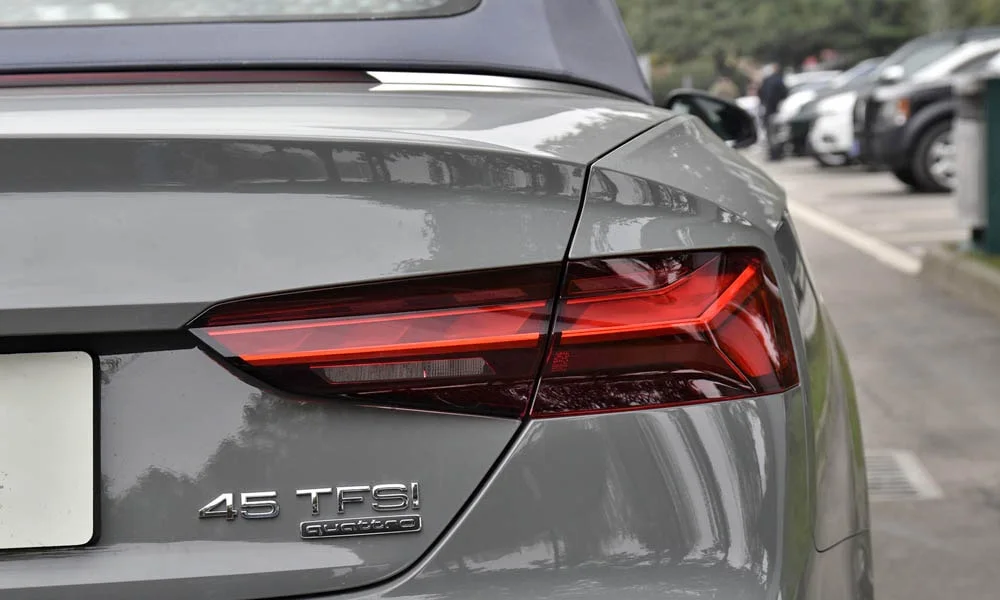 Фото Audi A5 (2024) — вид сзади, фото 4. Корма в сером цвете: графика фонарей и пластика пятой двери. Насадки выхлопа или их имитация внизу бампера различают версии Audi A5 (2024) — вид сзади, фото 4