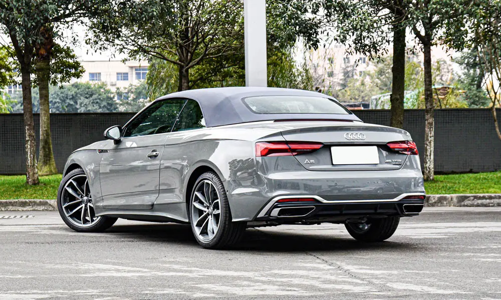 Фото Audi A5 (2024) — вид сзади, фото 7. Линия крыши, стойки и задняя дверь в сером исполнении. Светодиодная полоса или раздельные секции — задняя оптика стала главным украшением кормы Audi A5 (2024) — вид сзади, фото 7