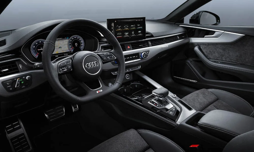 Фото Audi A5 — передняя панель, фото 4. Панель в тёмной отделке — видна компоновка экранов и органов управления. Минимум физических кнопок — ставка на экранное управление Audi A5 — передняя панель, фото 4