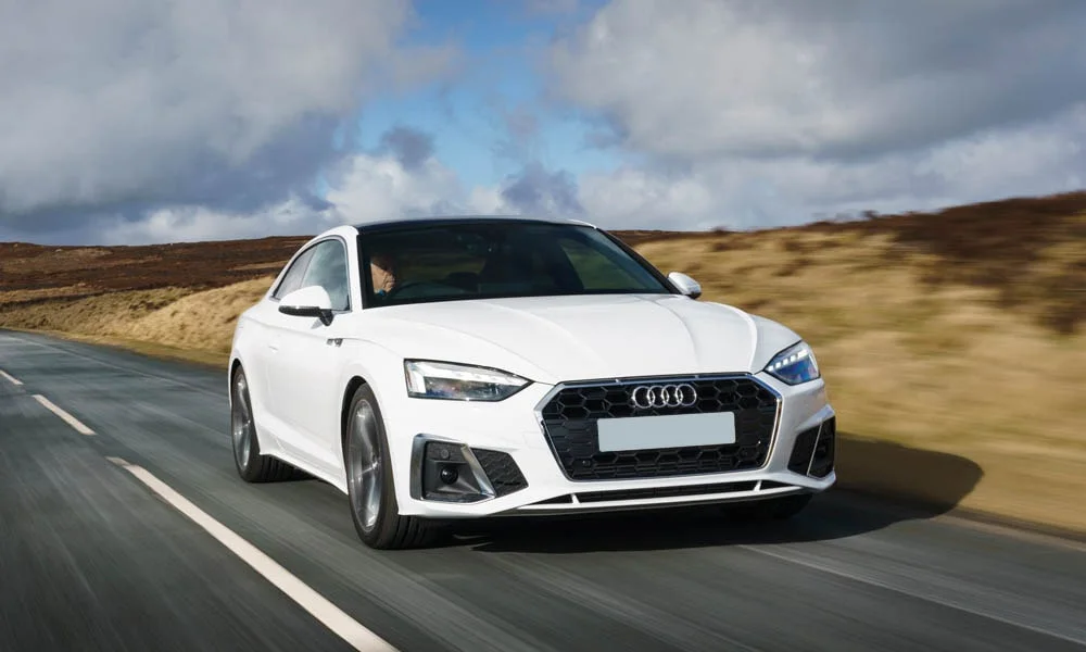 Фото Audi A5 — вид спереди, фото 11. Белый кузов, строгая симметрия оптики — базовый ракурс знакомства с дизайном. Дневные ходовые огни включаются автоматически с запуском Audi A5 — вид спереди, фото 11