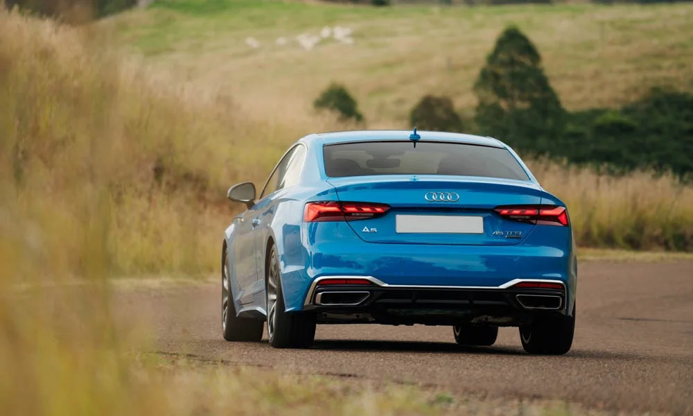 Фото Audi A5 — вид сзади, фото 17. Линия крыши, стойки и задняя дверь в синем исполнении. Насадки выхлопа или их имитация внизу бампера различают версии Audi A5 — вид сзади, фото 17