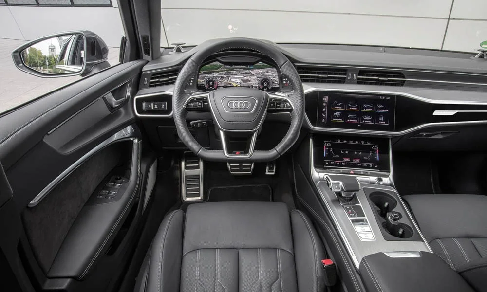 Фото Audi A6 Avant — передняя панель. Передняя панель в тёмной отделке: расположение экранов и дефлекторов. Минимум физических кнопок — ставка на экранное управление Audi A6 Avant — передняя панель