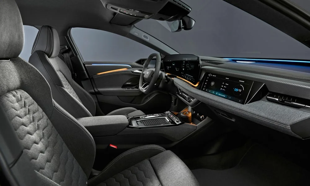 Фото Audi A6 Sportback e-tron (2024) — интерьер. Интерьер с тёмной отделкой — видно сочетание материалов панели и кресел. Уровень отделки читается по стыкам панелей и мягким поверхностям в зонах касания Audi A6 Sportback e-tron (2024) — интерьер