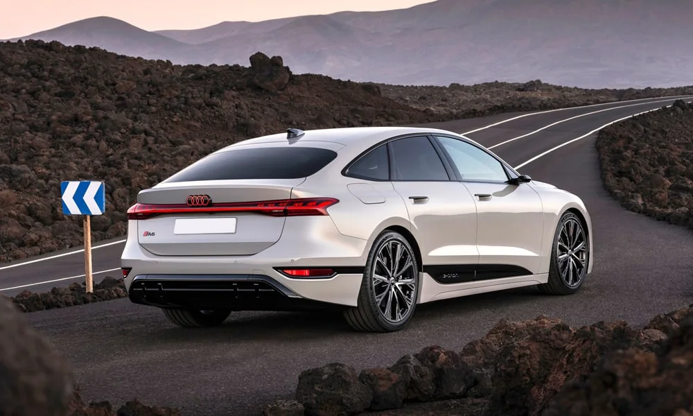 Фото Audi A6 Sportback e-tron (2024) — вид сзади, фото 6. Белый кузов сзади — фонари и бампер определяют ночной образ модели. Насадки выхлопа или их имитация внизу бампера различают версии Audi A6 Sportback e-tron (2024) — вид сзади, фото 6