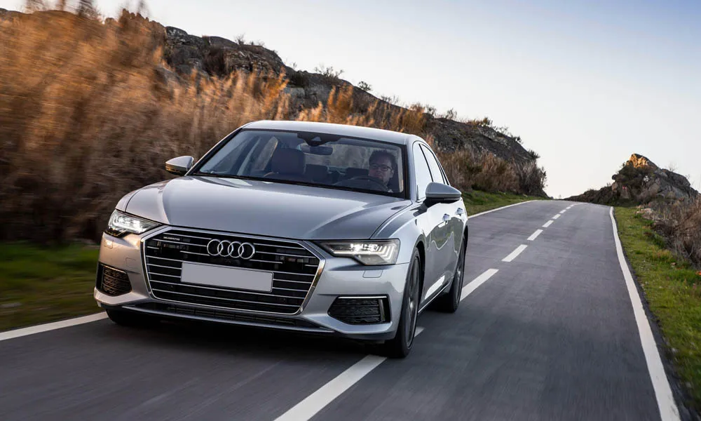 Фото Audi A6 — вид спереди, фото 5. Передок в серебристом исполнении — крупная светотехника и выразительный бампер. Рисунок ходовых огней — подпись модели, по нему её узнают в потоке Audi A6 — вид спереди, фото 5