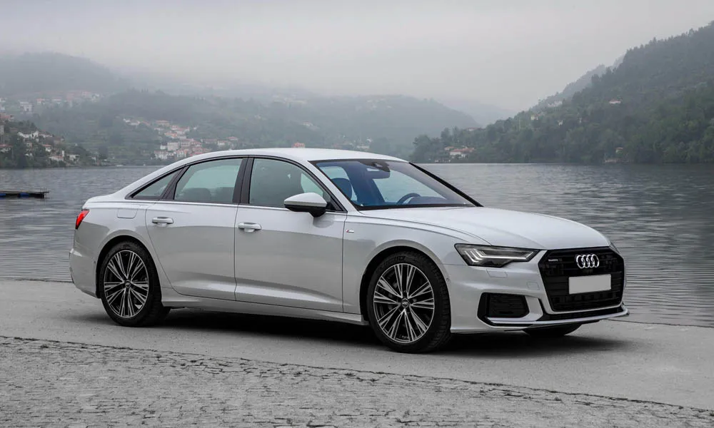 Фото Audi A6 — вид спереди, фото 8. Кузов в белом цвете: рисунок оптики и решётки задаёт узнаваемое «лицо» модели. Рисунок ходовых огней — подпись модели, по нему её узнают в потоке Audi A6 — вид спереди, фото 8