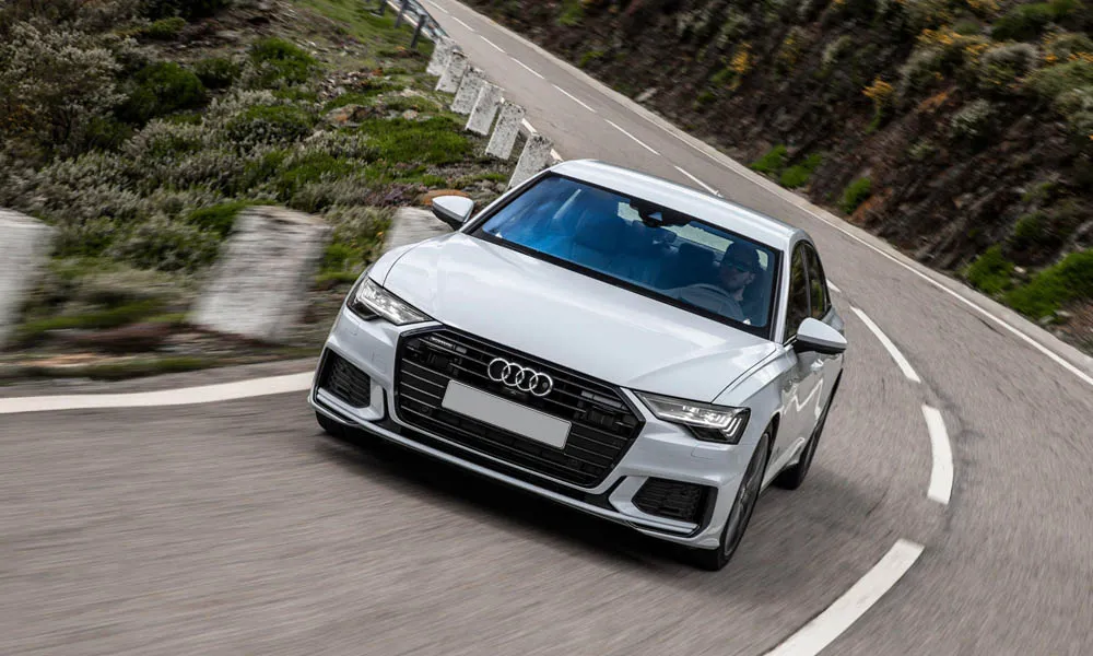 Фото Audi A6 — вид спереди, фото 10. Белый кузов, строгая симметрия оптики — базовый ракурс знакомства с дизайном. Дневные ходовые огни включаются автоматически с запуском Audi A6 — вид спереди, фото 10