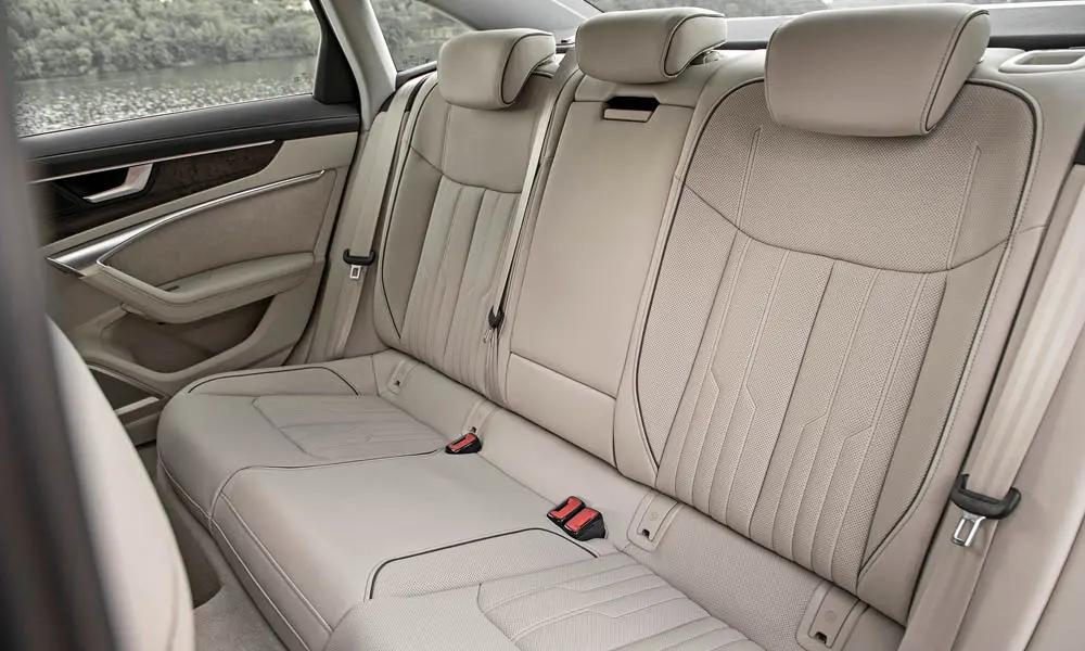 Фото Audi A6 — задние сиденья. Посадка второго ряда: подголовники и подлокотник. Крепления ISOFIX для детских кресел — в основании спинки Audi A6 — задние сиденья