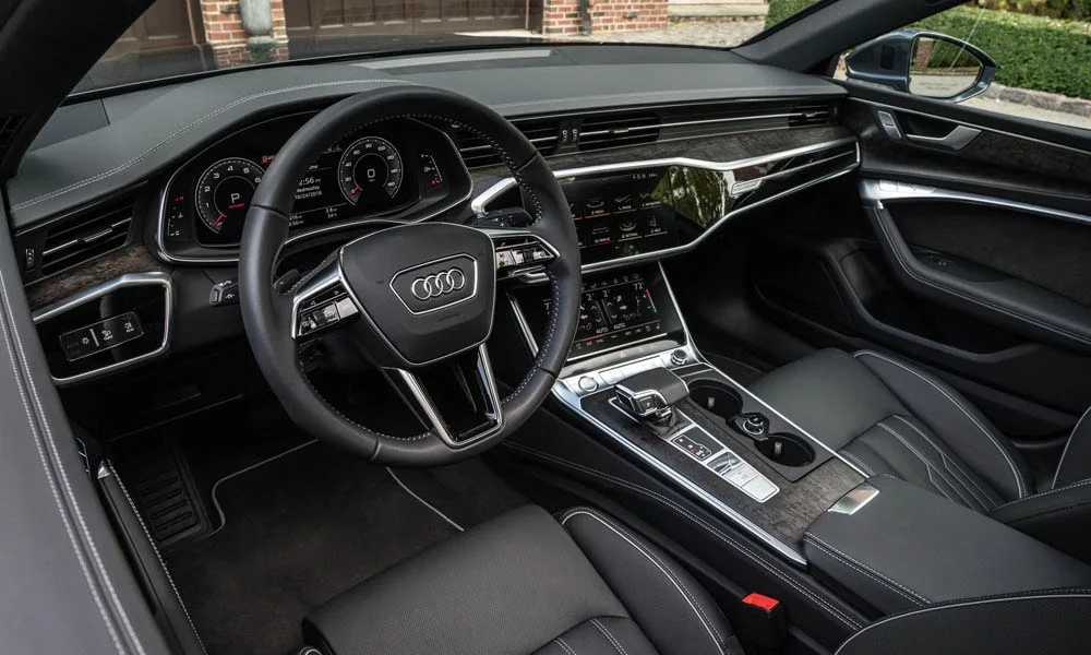 Фото Audi A7 Sportback — передняя панель. Передняя панель в тёмной отделке: расположение экранов и дефлекторов. Мягкие материалы верхнего яруса и вставки задают уровень интерьера Audi A7 Sportback — передняя панель