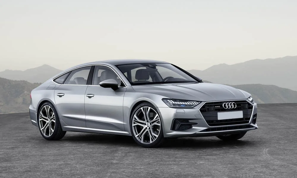 Фото Audi A7 Sportback — вид спереди, фото 8. Серебристый кузов, строгая симметрия оптики — базовый ракурс знакомства с дизайном. Дневные ходовые огни включаются автоматически с запуском Audi A7 Sportback — вид спереди, фото 8