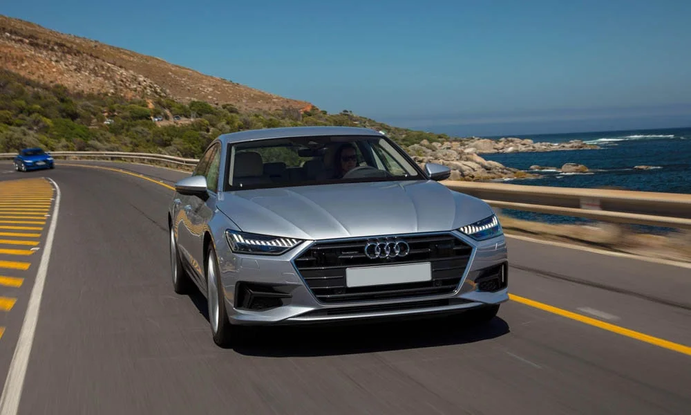 Фото Audi A7 Sportback — вид спереди, фото 9. Серебристый кузов, строгая симметрия оптики — базовый ракурс знакомства с дизайном. Рисунок ходовых огней — подпись модели, по нему её узнают в потоке Audi A7 Sportback — вид спереди, фото 9