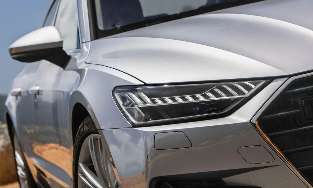 Фото Audi A7 Sportback — вид спереди, фото 11. Серебристый кузов, строгая симметрия оптики — базовый ракурс знакомства с дизайном. Рисунок ходовых огней — подпись модели, по нему её узнают в потоке Audi A7 Sportback — вид спереди, фото 11