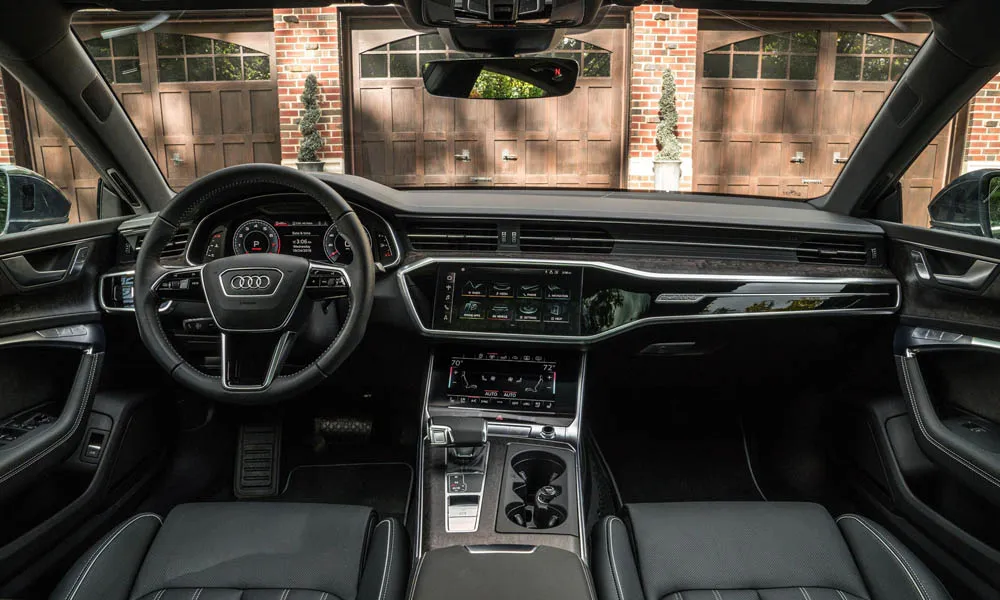 Фото Audi A7 Sportback — интерьер. Салон в тёмной отделке: архитектура передней панели, консоль и кресла. Светлая гамма зрительно расширяет салон, тёмная — практичнее в уходе Audi A7 Sportback — интерьер