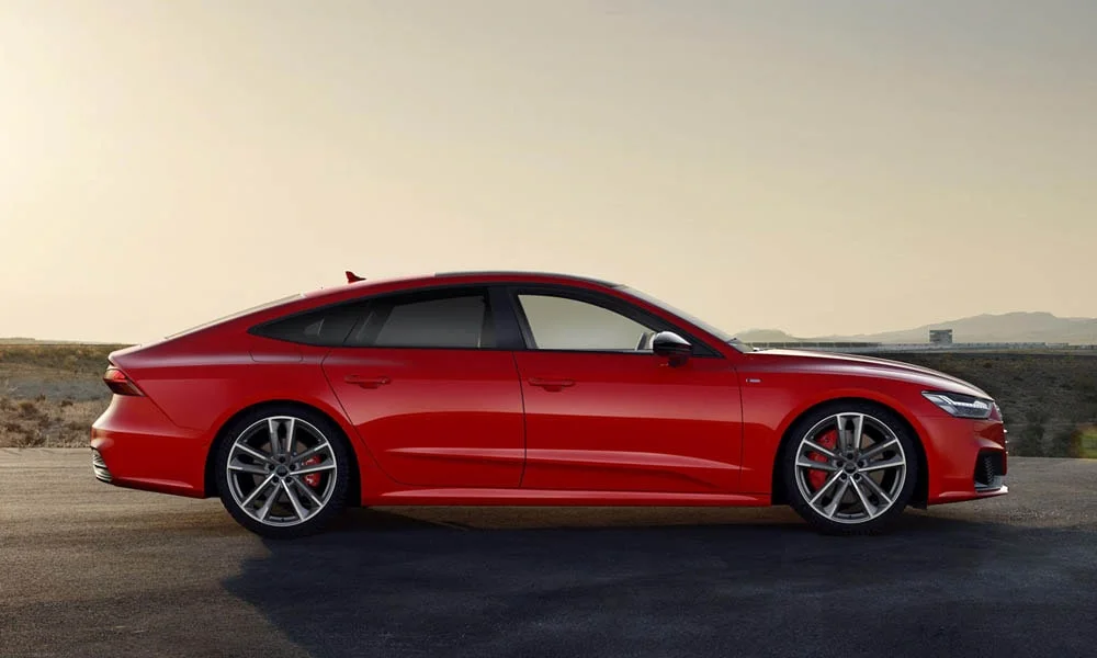 Фото Audi A7 Sportback — вид сбоку. Красный кузов в профиль — пропорции, высота посадки и дизайн дисков. Длинная база — простор второго ряда; короткие свесы упрощают парковку Audi A7 Sportback — вид сбоку